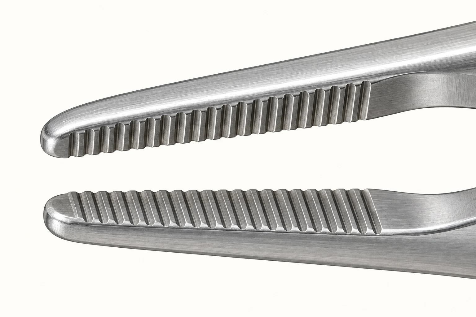 Open instrument jaws showing closely spaced gripping ridges and grooves on their inner surfaces.